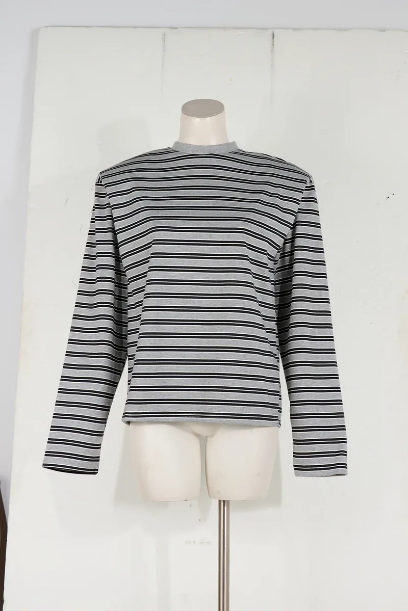 A black and white striped longsleeve on a headless dressmaker's bust against a plain wall
